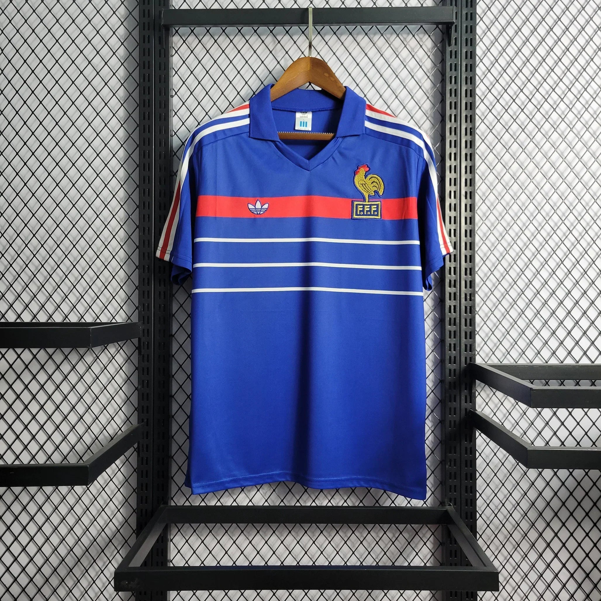 Maillot rétro de l'équipe de France 1985/86 de la marque Le 12, maillot de football vintage avec logo et design d'époque.